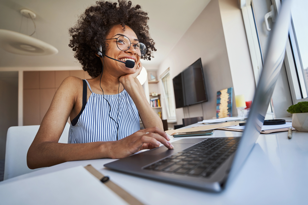 Work from Home Call Center Agent Image of a young woman who is an InfoCision Work from Home Contact Center Agent, taking a call from a non-profit and helping with their CX
